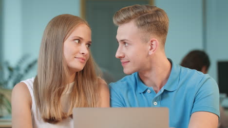 happy couple discussing project at coworking. closeup guy flirting with girl