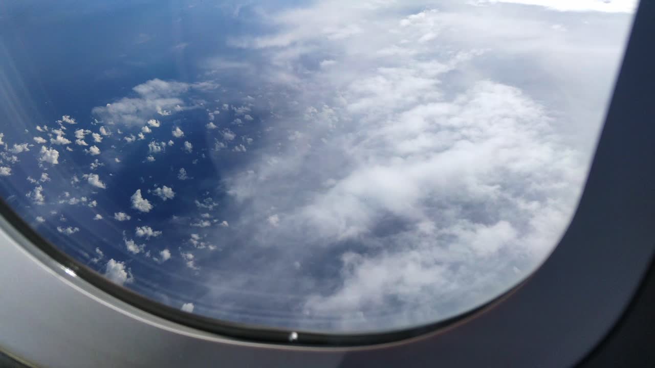 vista desde el avión que pasa sobre nubes altas, sobre el océano azul