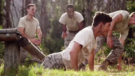 soldados militares arrastrándose bajo la red durante el curso de obstáculos 4k