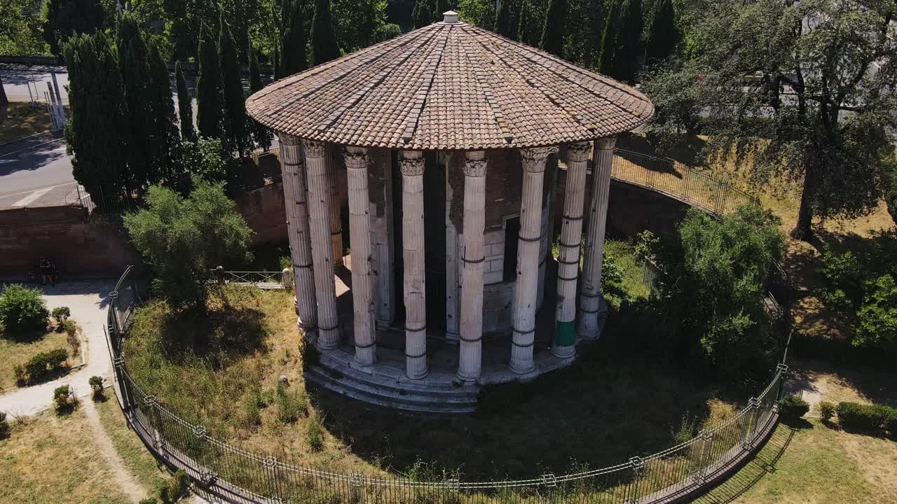 Iconic circular Roman temple with marble columns standing amid historic ruins