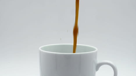 verter el café en una taza a cámara lenta de cerca