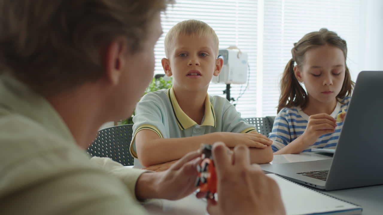 Tutor che parla con dei bambini a una lezione di programmazione
