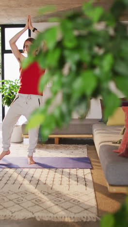 video vertical de una mujer transgénero caucásica no binaria practicando yoga, meditando