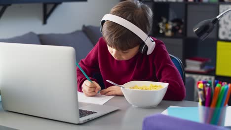 Handheld-video-of-boy-doing-homework-during-breakfast