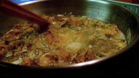 frying and flipping seafood in stainless steel pan on gas stove