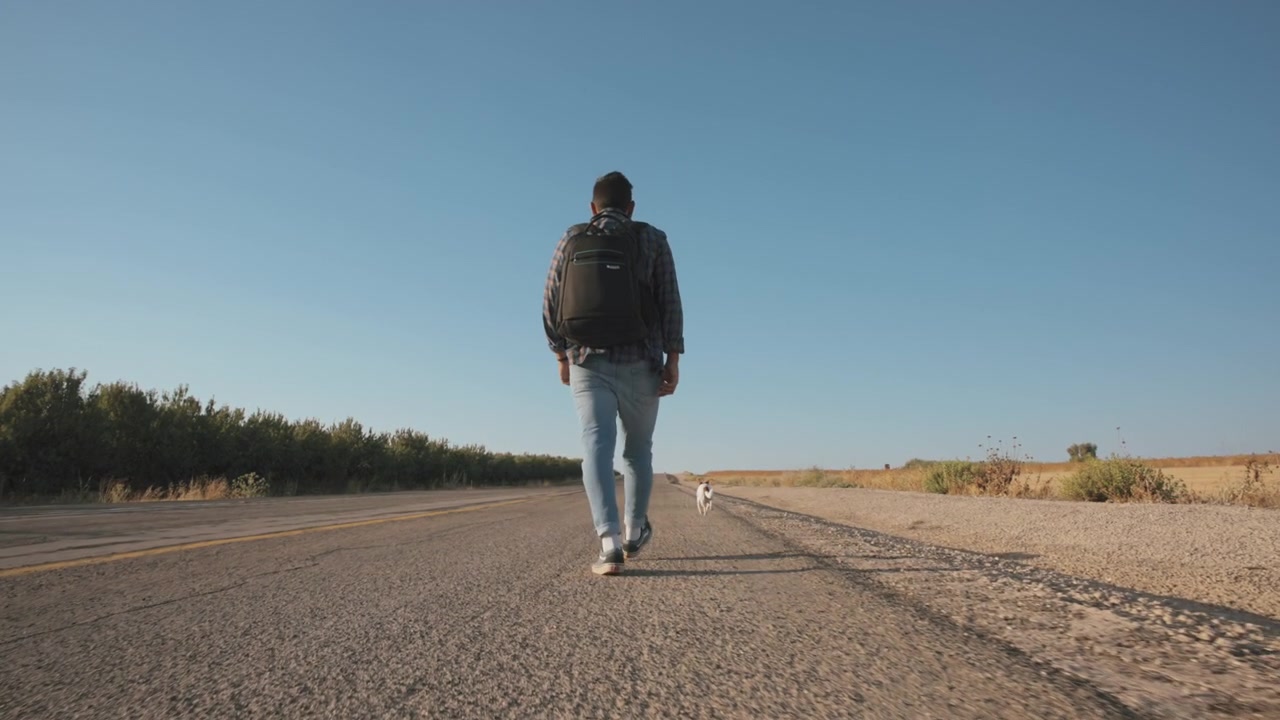 Hombre camina por el arcén de una carretera