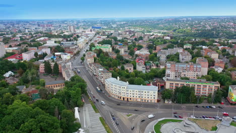 main city street in the urban downtown. cars running by the multilane road. green park in the centre. top view.