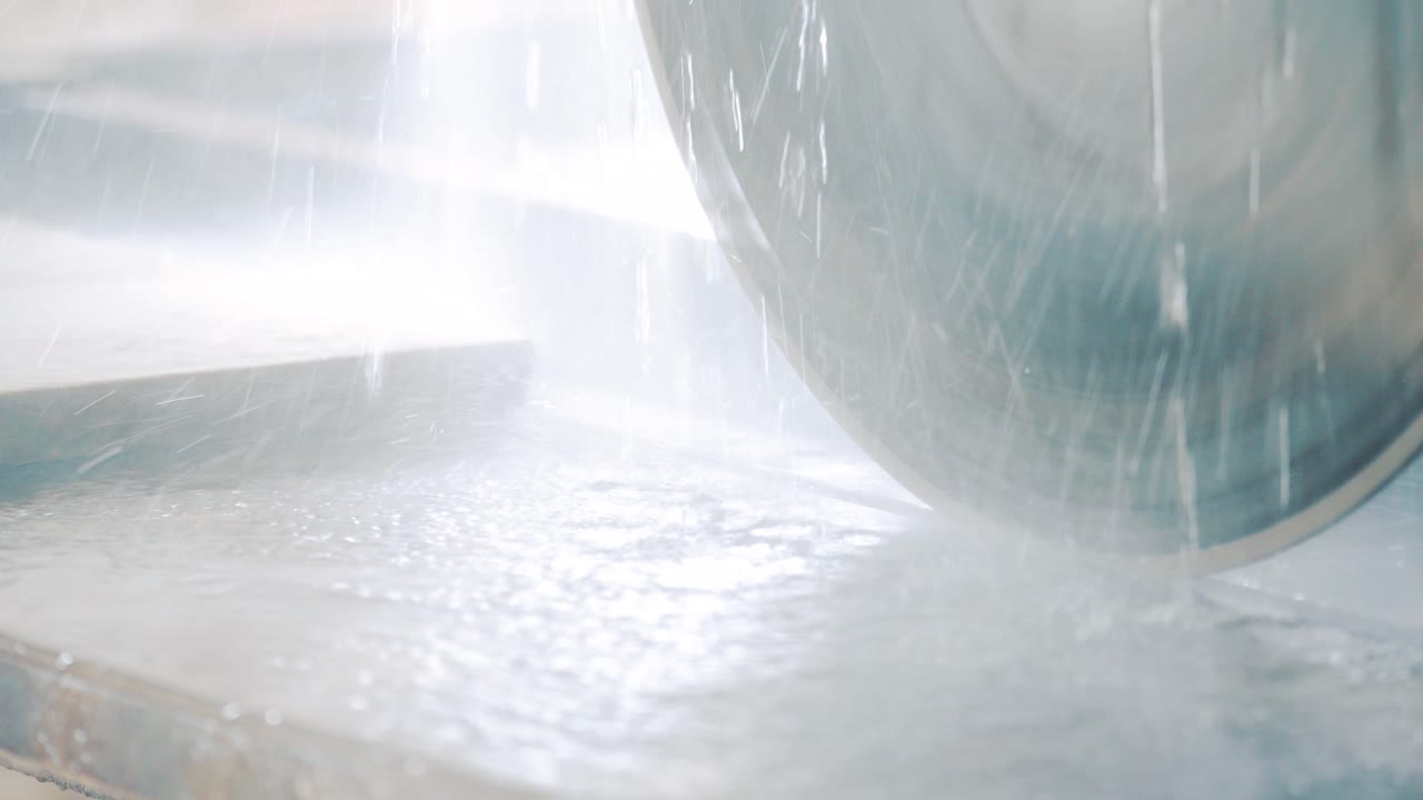 Beginning of the launch of a circular saw on an electric stone cutting machine. Drops of water on the table and saw