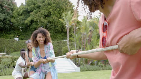 diverse group of friends enjoy a tug-of-war game outdoors