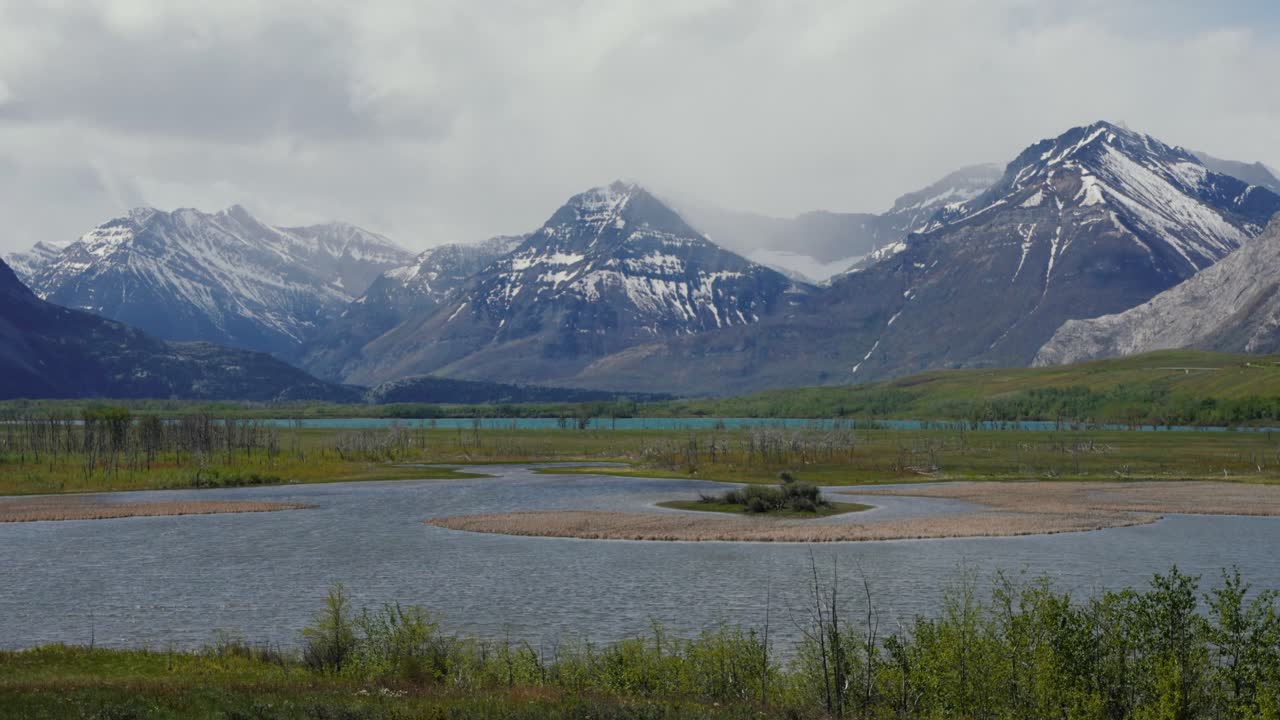 Waterton Lakes National Park landscape showing snow capped mountains and a lake, in Canada