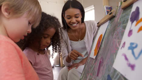 Profesor-En-La-Escuela-Montessori-Ayudando-A-Los-Niños-En-La-Clase-De-Arte.