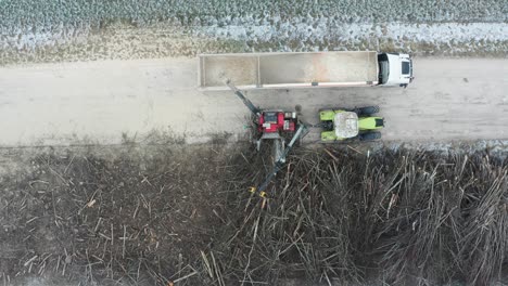 vista aérea de la trituradora de madera soplar madera triturada en el remolque de carga del camión