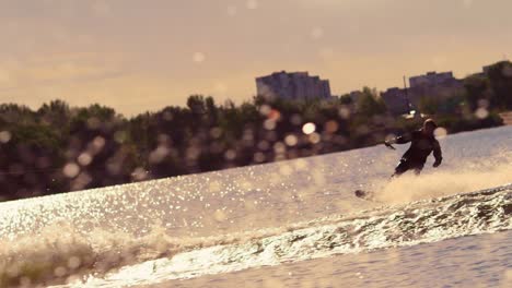 water skier moving fast in splashes of water at sunset. extreme watersports