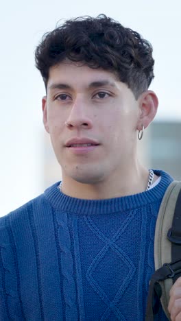 young latin american student looking around in the city. vertical