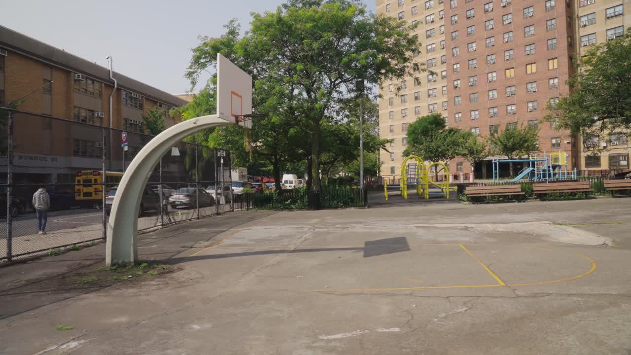 Empty basketball court in the backyard of the school with Highrise buildings in background, New York, USA