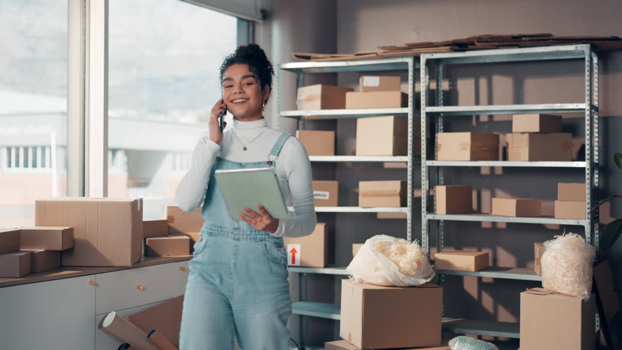 Donna al telefono in una piccola impresa, circondata da scatole