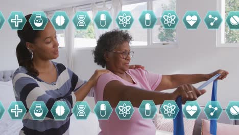 Animation-of-medical-icons-over-senior-woman-exercising-using-rubber-band-with-female-therapist