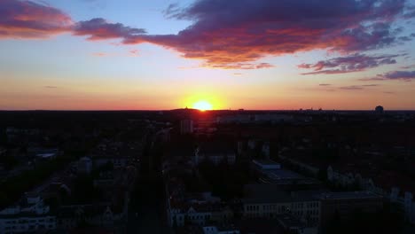 sun sets over a city with pink cotton candy clouds dramatic aerial view flight panorama overview drone footage berlin steglitz, golden hour summer 2022 view from above tourist guide by philipp marnitz