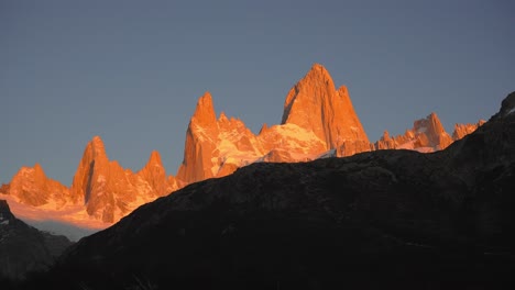 goldene gipfel des fitzroy-massivs bei sonnenaufgang gegen einen klaren himmel in patagonien