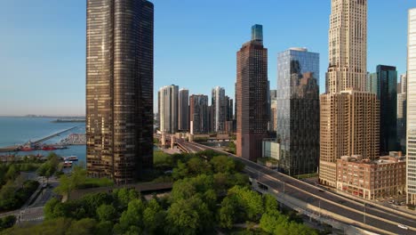 cars traveling past city highrses next to lake