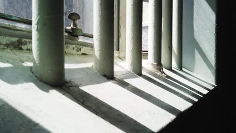 rastreando más allá de las sombras de las barras en la ventana de una celda de prisión en la prisión de robben island