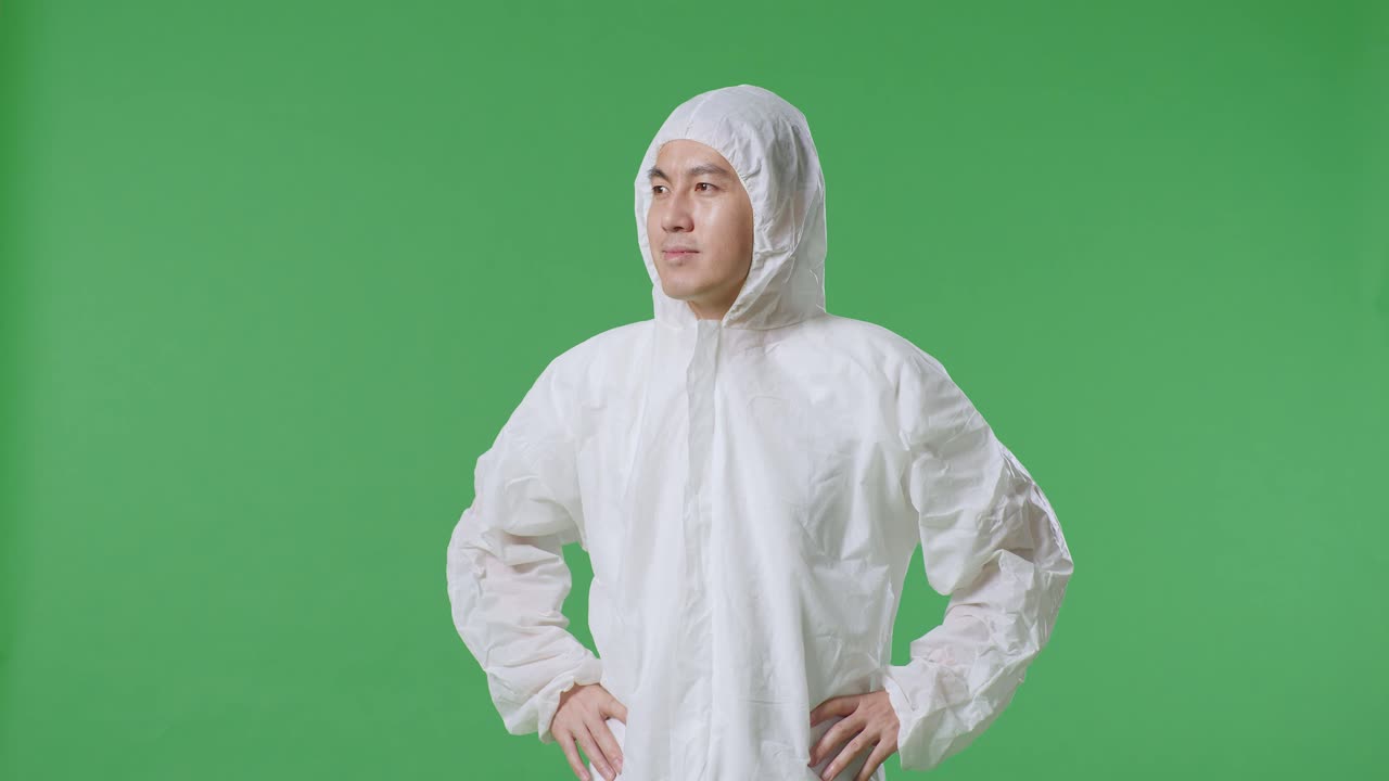 азиатский ученый-мужчина кладет руки на бедро и смотрит вокруг на зеленом фоне экрана