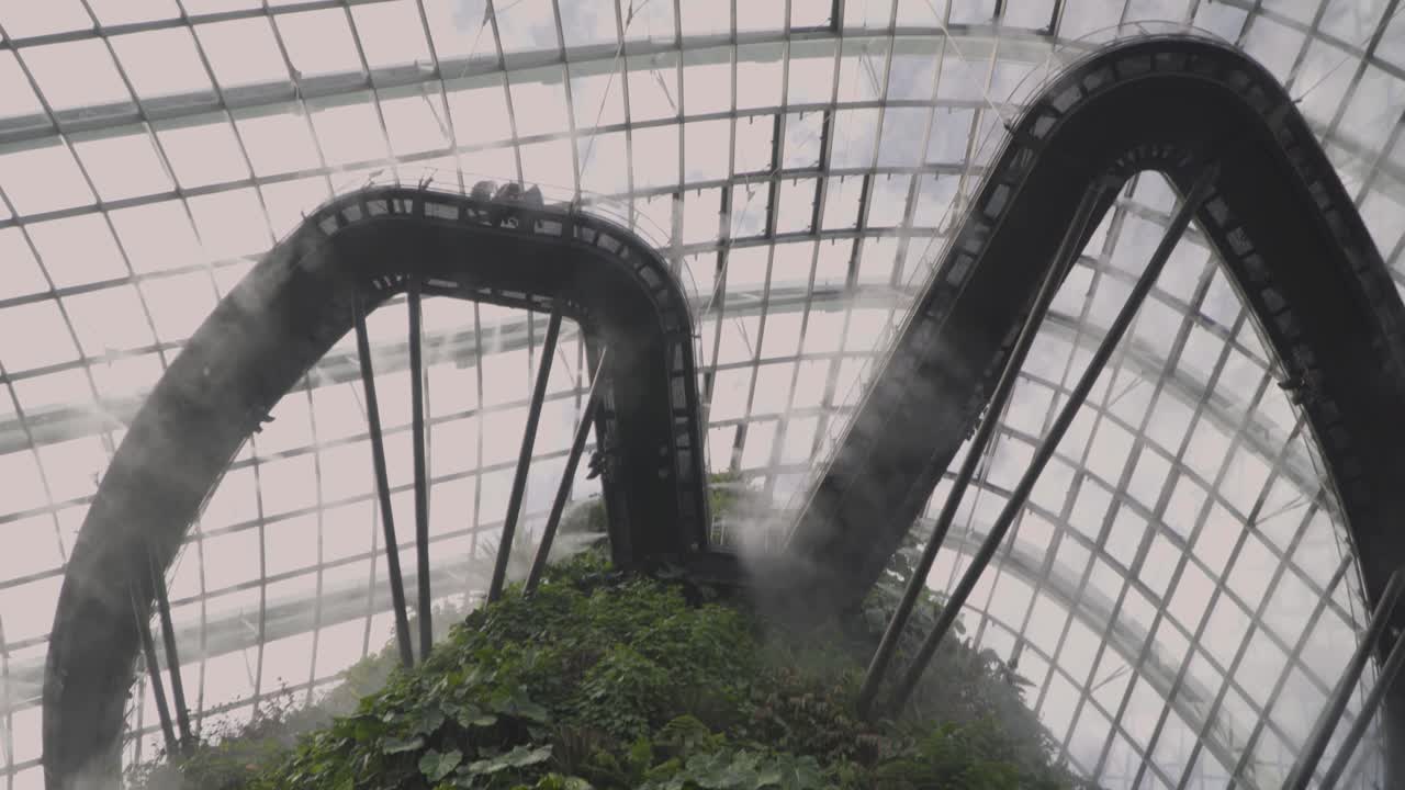 싱가포르 만 옆 정원에서 관광객들과 안개를 내뿜는 구름 숲 산을 올려다본다