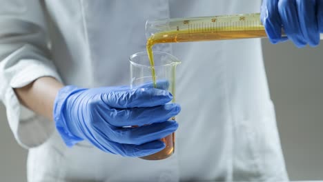 científico vertiendo líquido en un vaso