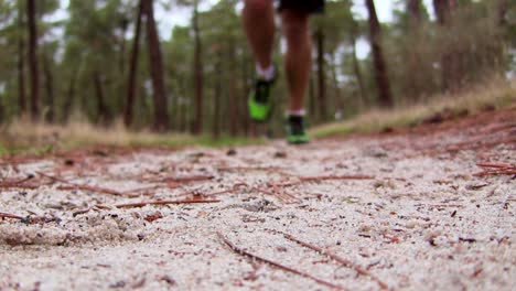 runner running toward camera in forest with sneaker detail