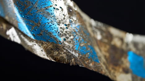 close-up view of a weathered, wet, and dirty piece of tape.