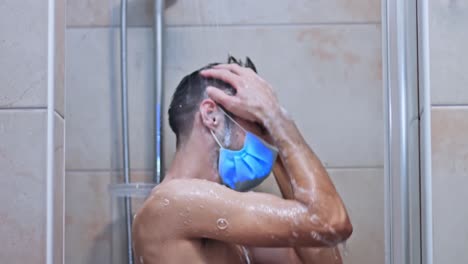 joven caucásico parado en la ducha con máscara médica