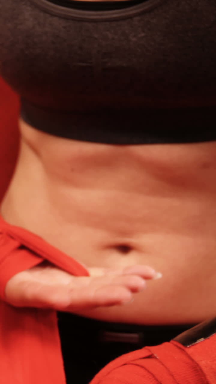 Pugilessa con fascia rossa al polso in palestra