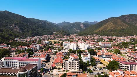 Ein-Drohnenflug-über-Die-Kurstadt-Und-Hotels-Vor-Dem-Blauen-Himmel-Der-Von-Grünen-Hügeln-Umgebenen-Häuser-Der-Hotelkomplexe