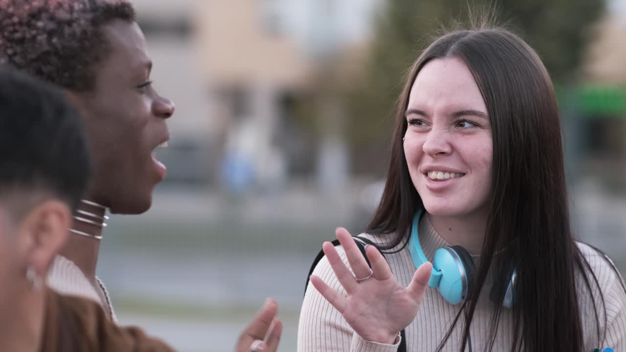 Cool transgender man and a friend talking together siting outdoors