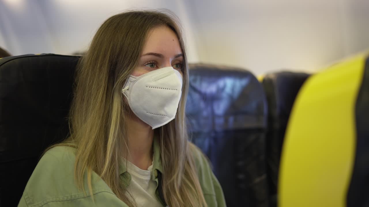 Woman in medical mask inside the airplane