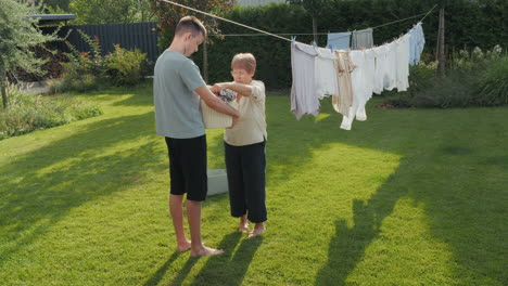 grandparent and grandson doing laundry outdoors