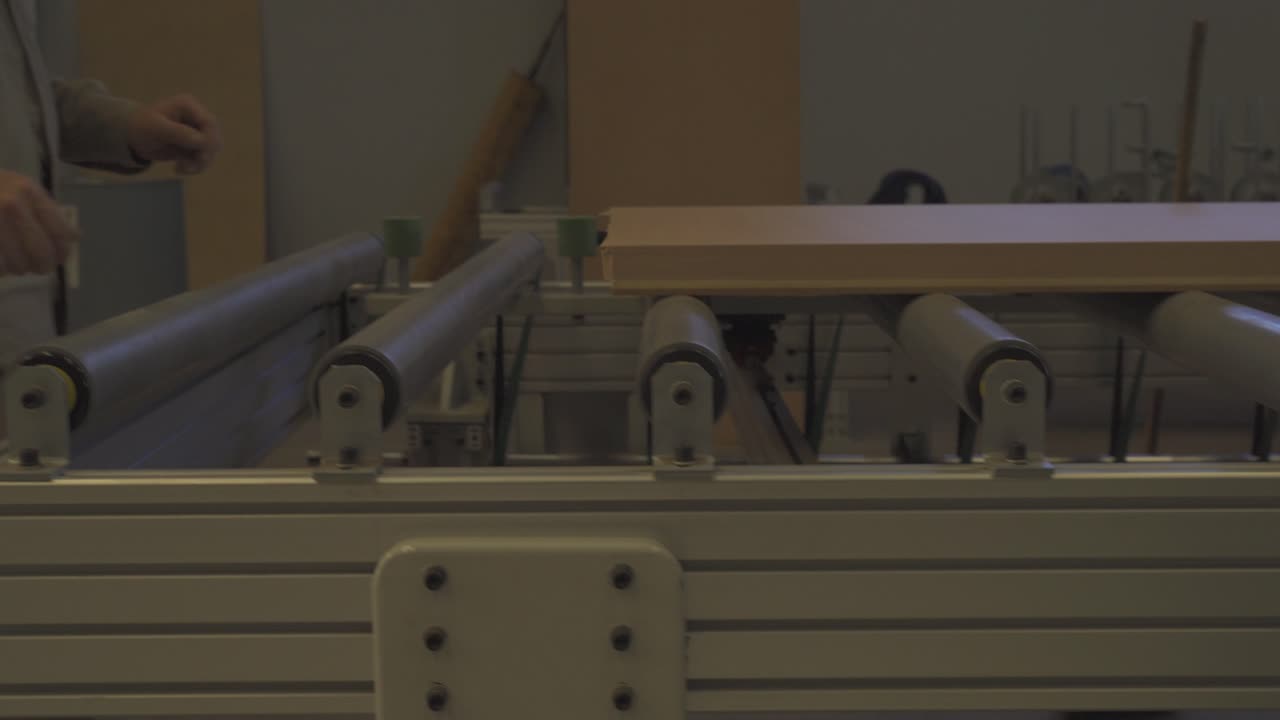 목제 문 공장의 작업자가 생산 라인에서 완제품을 가져옵니다.