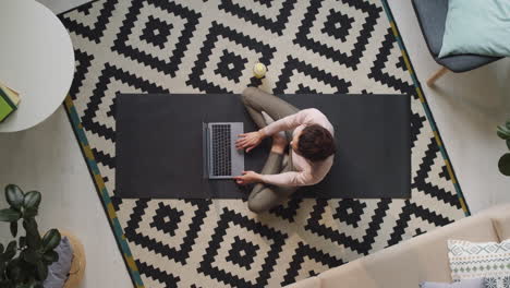 woman sitting on floor and using laptop at home