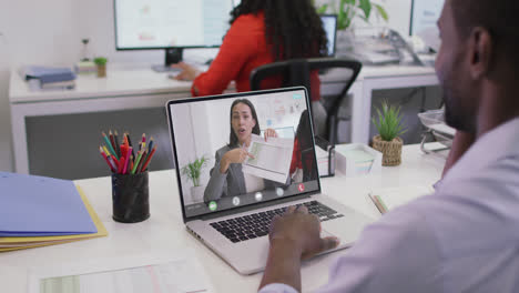 Video-of-african-american-man-having-video-call-on-laptop-with-biracial-female-coworker