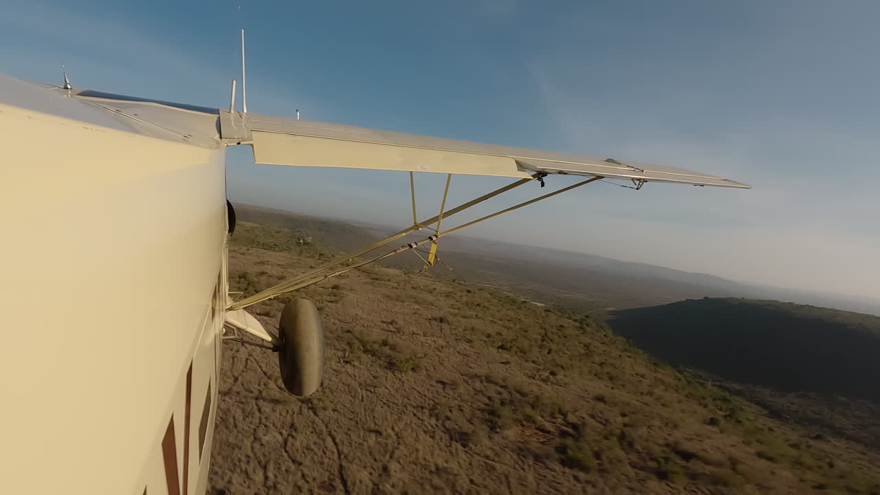 Small air plane side view over shrubs and valley