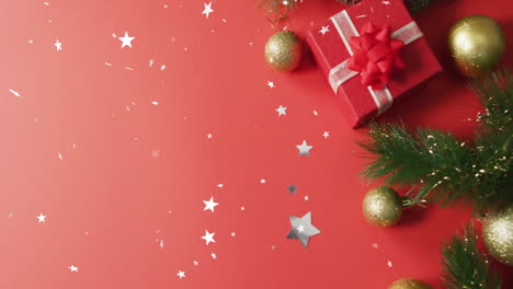 animation of stars falling over christmas gift on red background