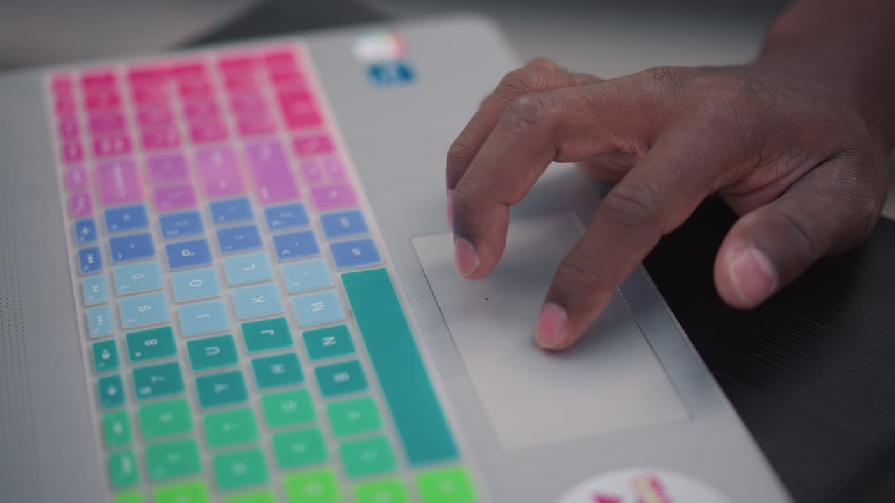 dj hands on colorful laptop, closeup of hands navigating trackpad and rainbow keyboard cover during live mixing fingertip gestures triggering loops and samples, electronic beat creation, focused