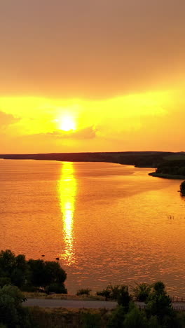amazing view of golden path over the river at sunset. fantastic landscape of nature in the evening. aerial view. camera moves forward. vertical video