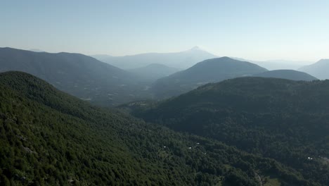 Dolly-out-of-the-mountains-of-southern-chile-on-a-sunny-day-with-the-villarrica-volcano-in-the-background---drone-shot