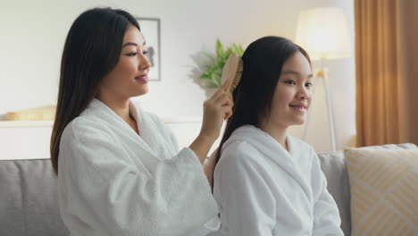 mother brushing daughter's hair