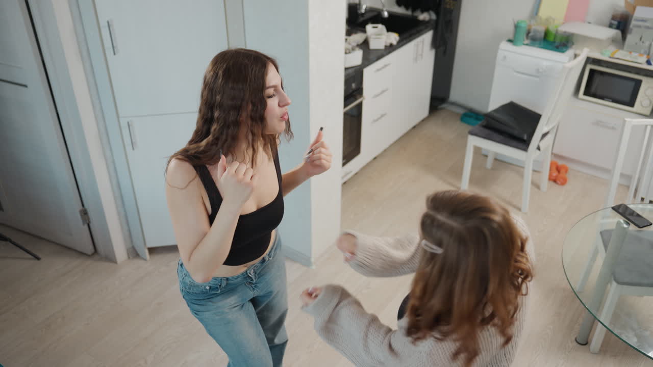 Caucasian Siblings Bonding In Kitchen, Casual Embrace Captured During Lipstick Application In Kitchen, Caucasian Sisters Enjoying Heartfelt Bonding Session While Practicing Makeup And Chatting