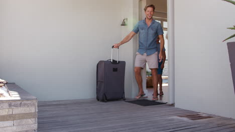 family with luggage leaving house for summer vacation