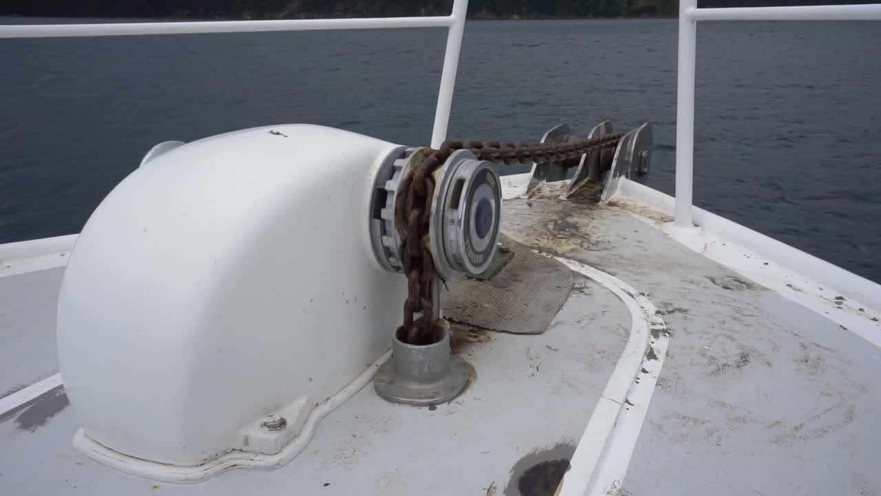 Electric boat anchor on chain being pulled up