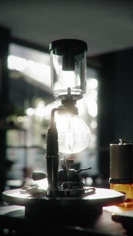 close-up of a siphon coffee brewer in a cozy café setting