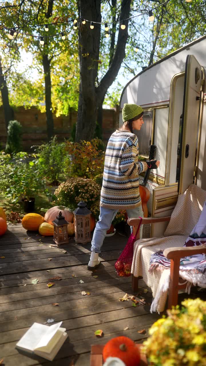 빈티지 트레일러에서 가을을 즐기는 여자